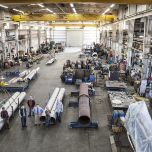 Mixed race team of workers and management people in a large sheet metal factory Mixed race team of workers and management people in a large sheet metal factory